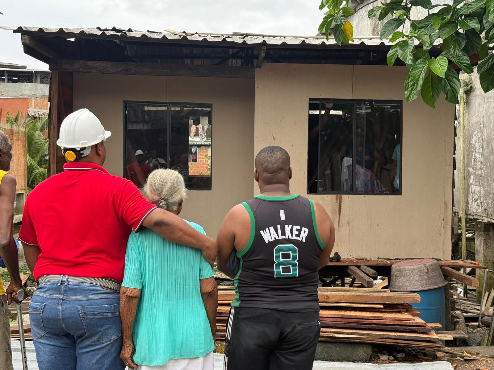 Wilvo con una familia frente a una vivienda en obra
